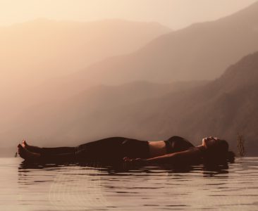 Morning light with Beautiful Attractive Asian woman practice yoga Dead Body or Savasana on the pool above the Mountain peak in front of beautiful nature views in SAPA vietnam,so comfortable,Warm Tone